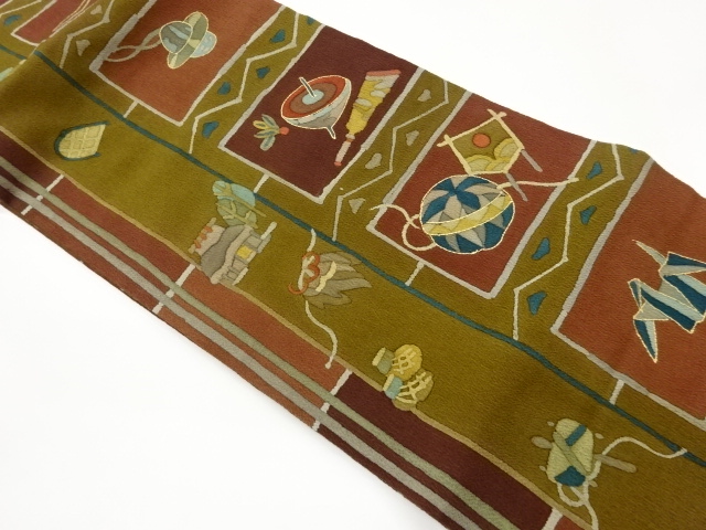 縮緬地金彩玩具に屋敷・幾何学模様名古屋帯